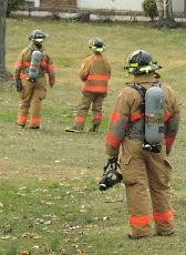 3 firemen suited up to enter a building